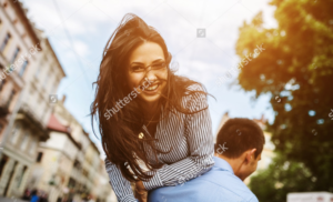 Stock photo of man carrying a woman on his shoulder.