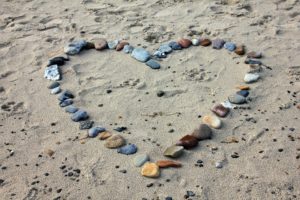 Rocks on the sand laid out in a heart shape