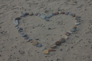 Rocks on the sand laid out in a heart shape